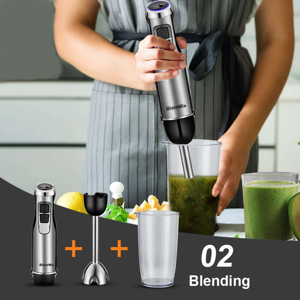 Handheld immersion blender mixing green smoothie in kitchen with accessories and ingredients
