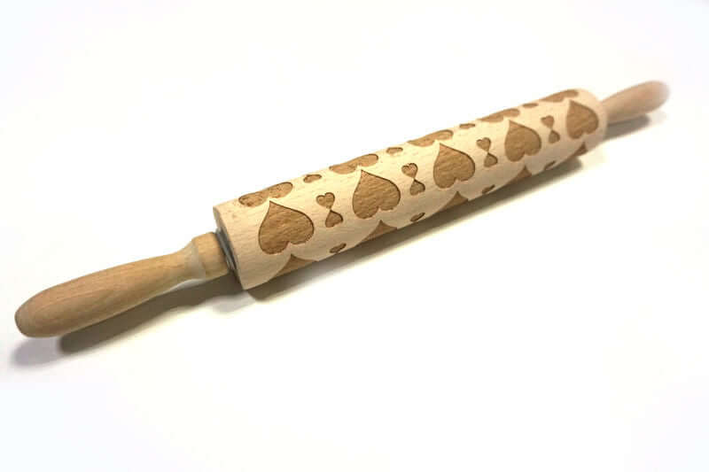 Wooden heart embossed rolling pin for baking on white background