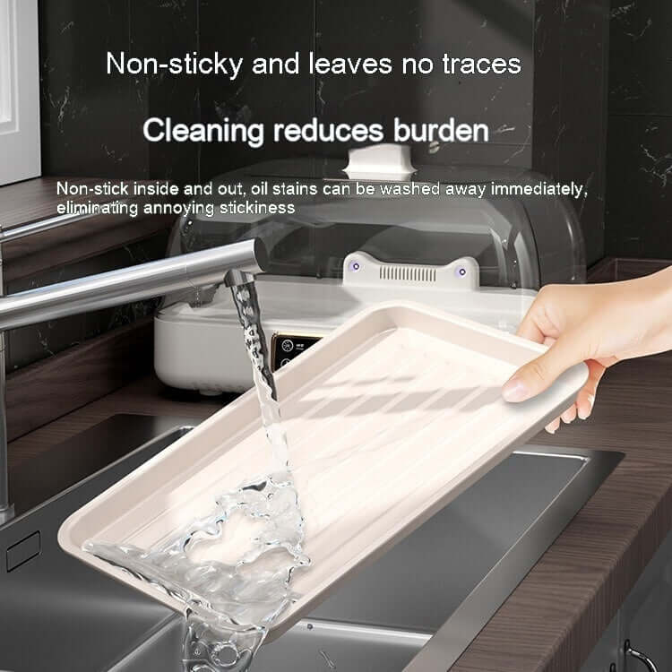 Non-stick kitchen tray being rinsed under tap water in a modern sink, easy to clean.