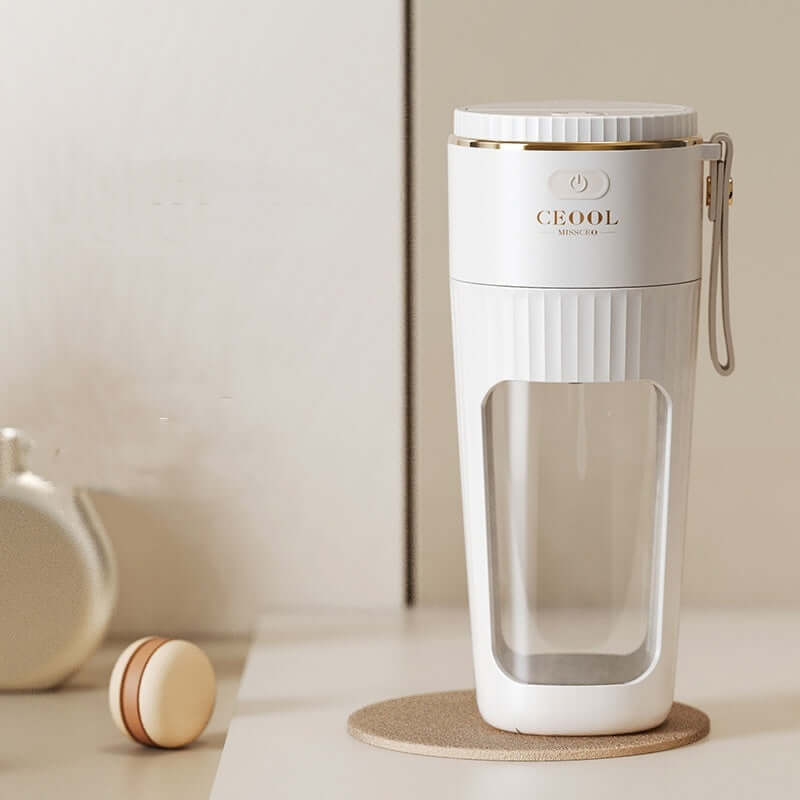 Modern white portable blender with clear cup on kitchen countertop
