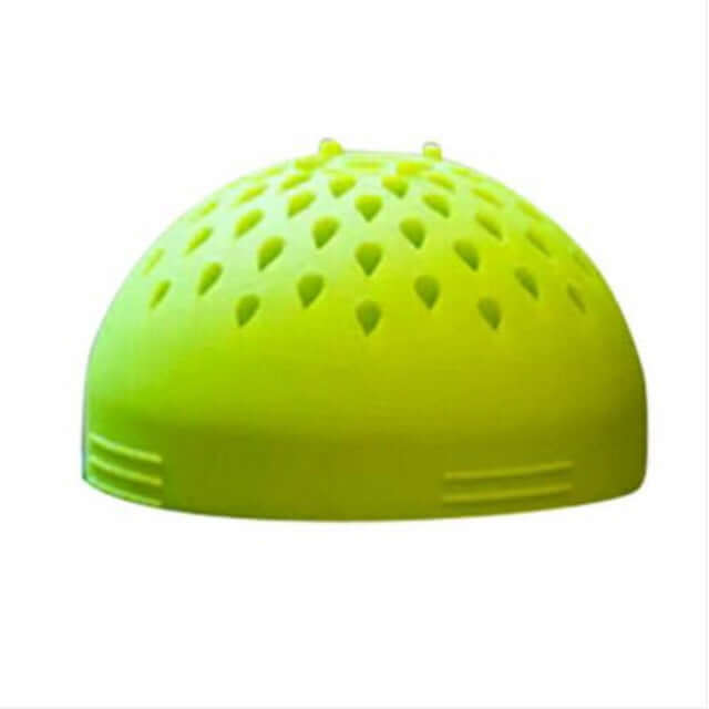Green plastic kitchen strainer dome with ventilation holes, utensil on white background