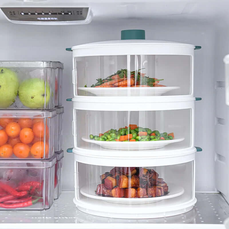 Stackable food storage containers with plates of vegetables inside a refrigerator