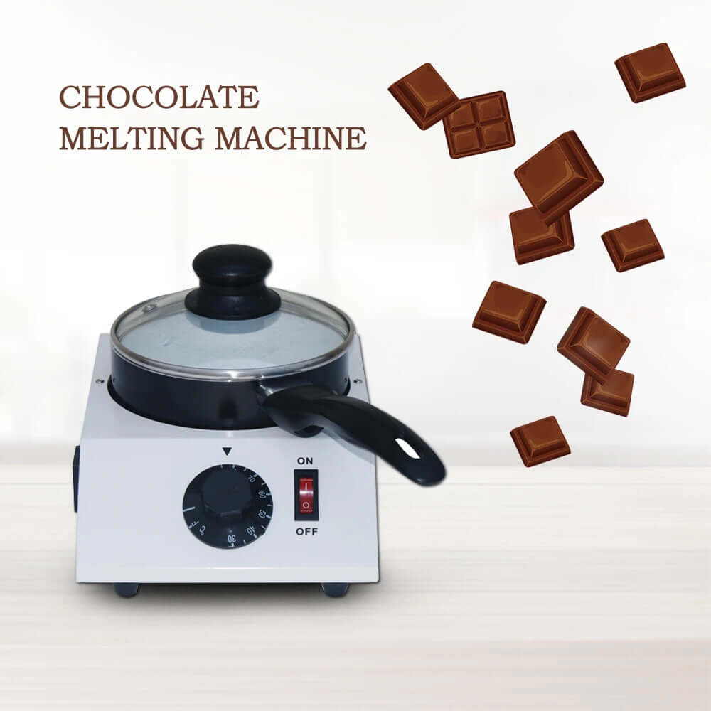 Electric chocolate melting machine with lid and falling chocolate pieces on kitchen counter