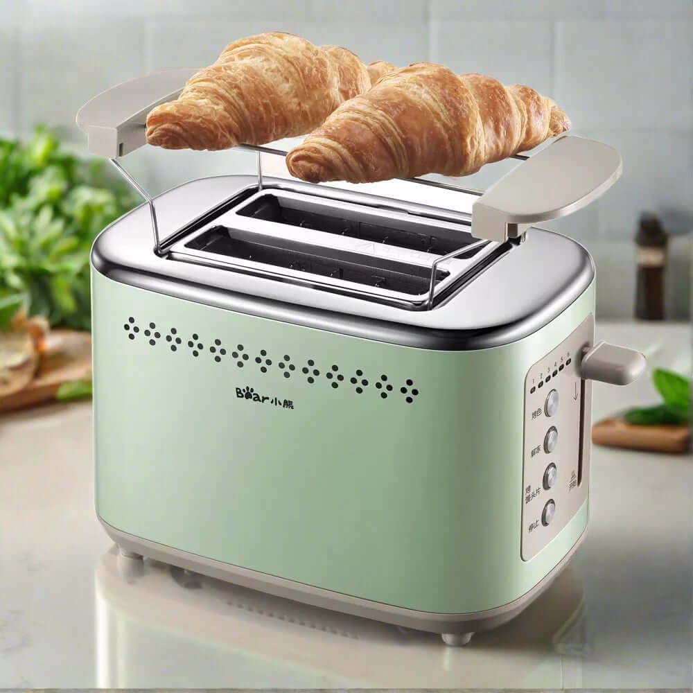 Mint green toaster with croissants warming on top, modern kitchen counter background