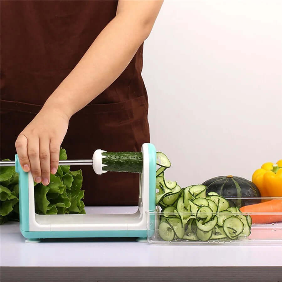 Person using a vegetable spiralizer to slice cucumber in a kitchen setting