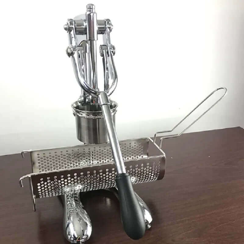 Stainless steel potato ricer and vegetable press kitchen tool on a wooden table