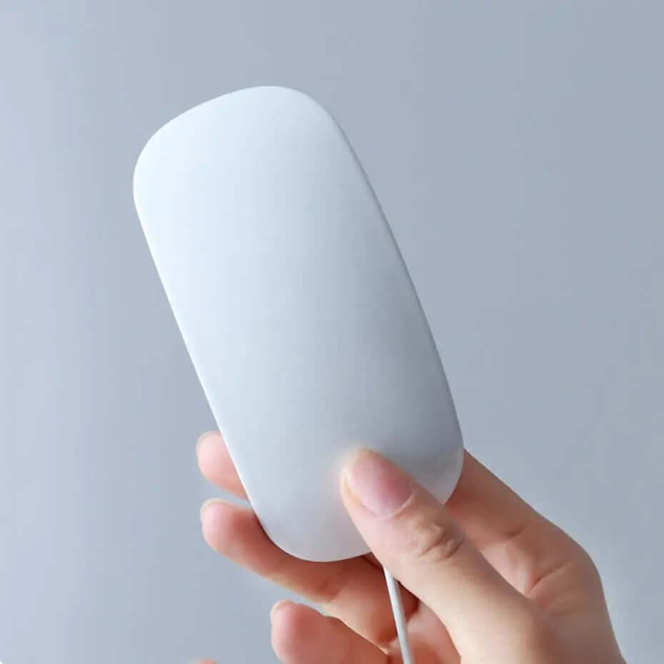 Hand holding a minimalist white electronic kitchen gadget with a smooth, modern design