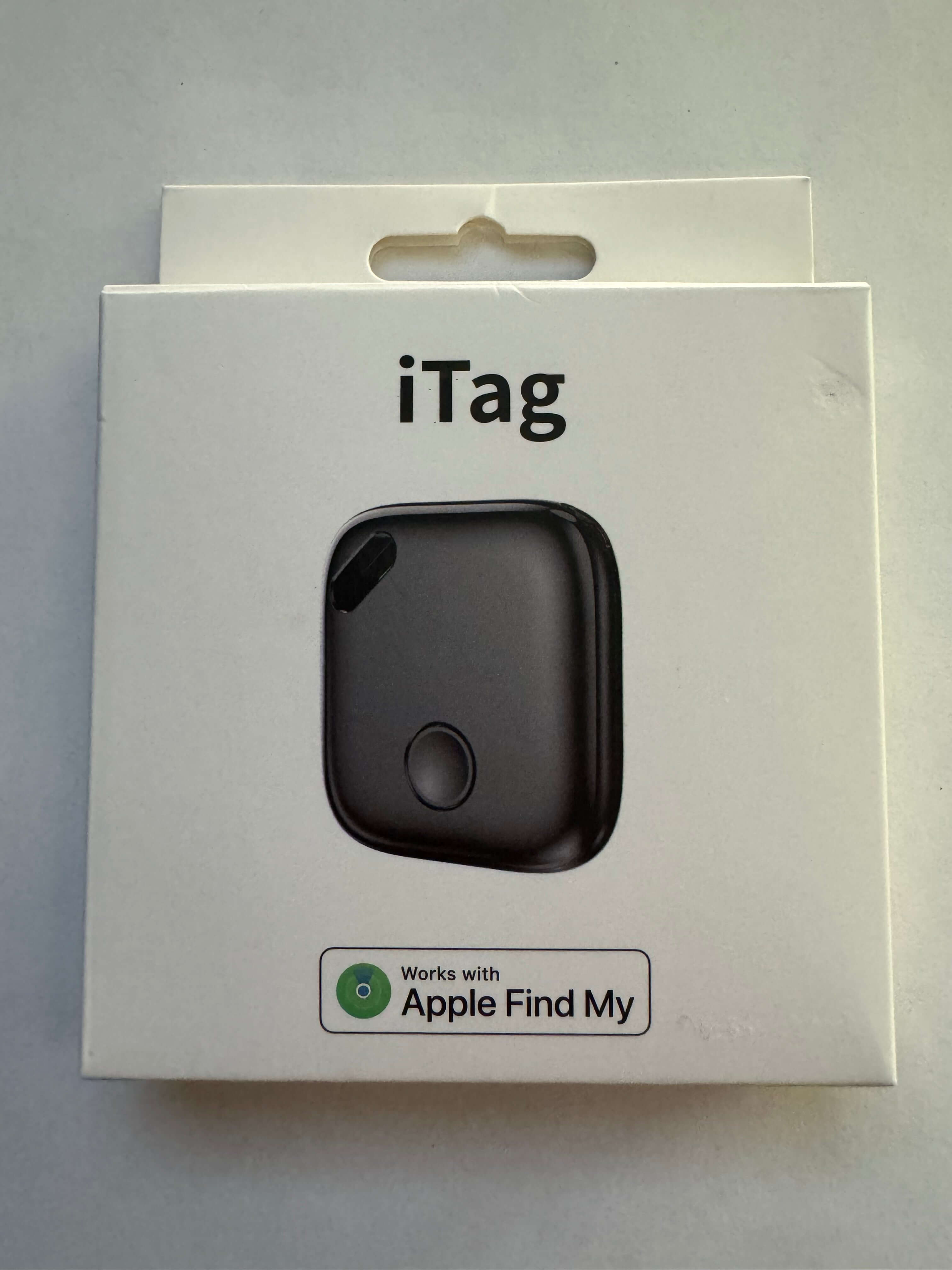 Black iTag Bluetooth tracker in packaging, compatible with Apple Find My, on white background