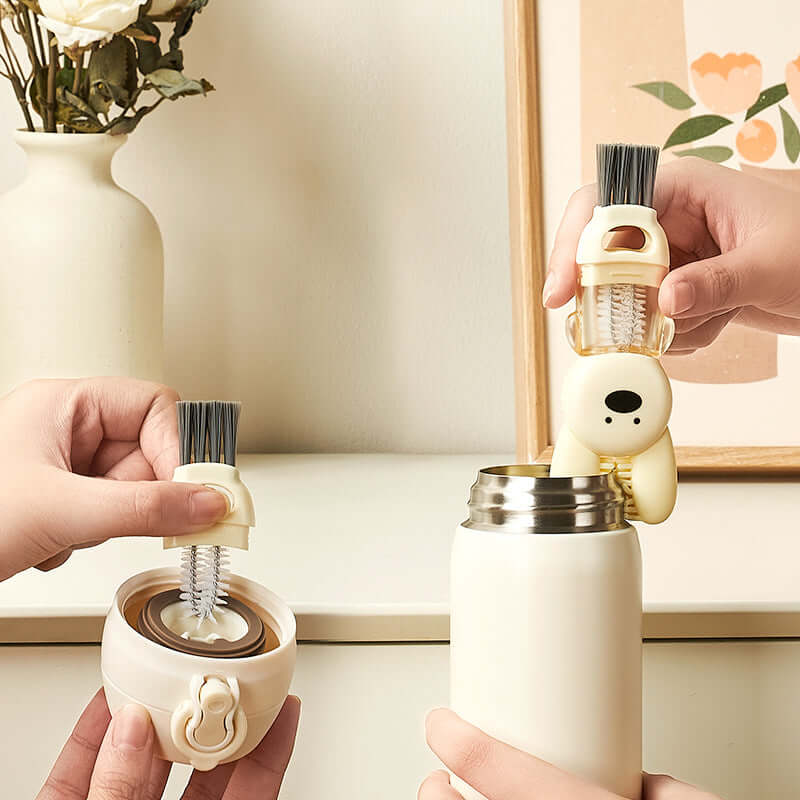 Hand using cute animal-shaped bottle cleaning brush on water bottle lid and thermos