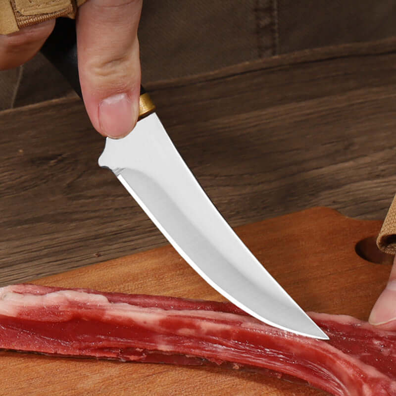 Sharp kitchen knife slicing raw meat on a wooden cutting board, close-up view.