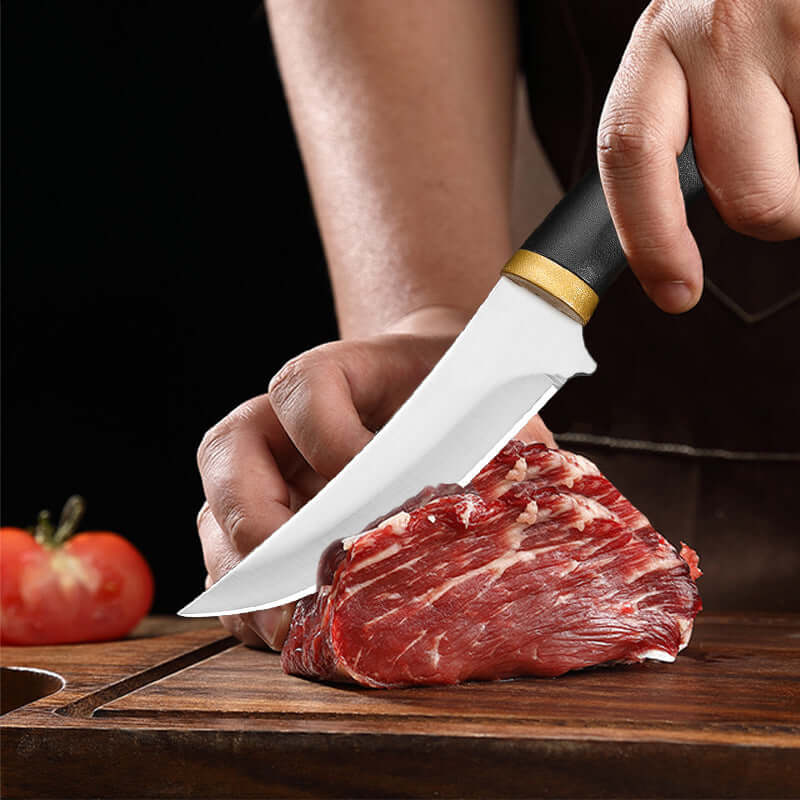 Chef slicing raw beef with a sharp kitchen knife on a wooden cutting board