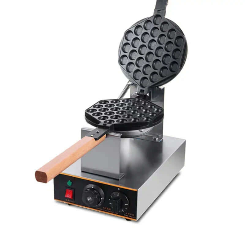 Bubble waffle maker with wooden handle and open non-stick plates on kitchen countertop