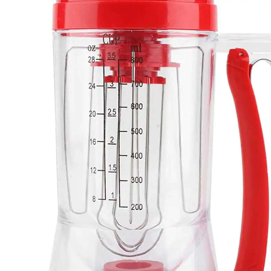 Clear plastic batter dispenser with red lid and handle, measurement markings visible