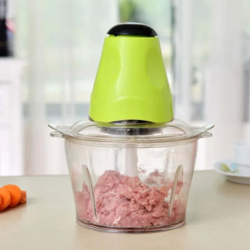 Electric meat grinder with transparent bowl and green lid on kitchen countertop