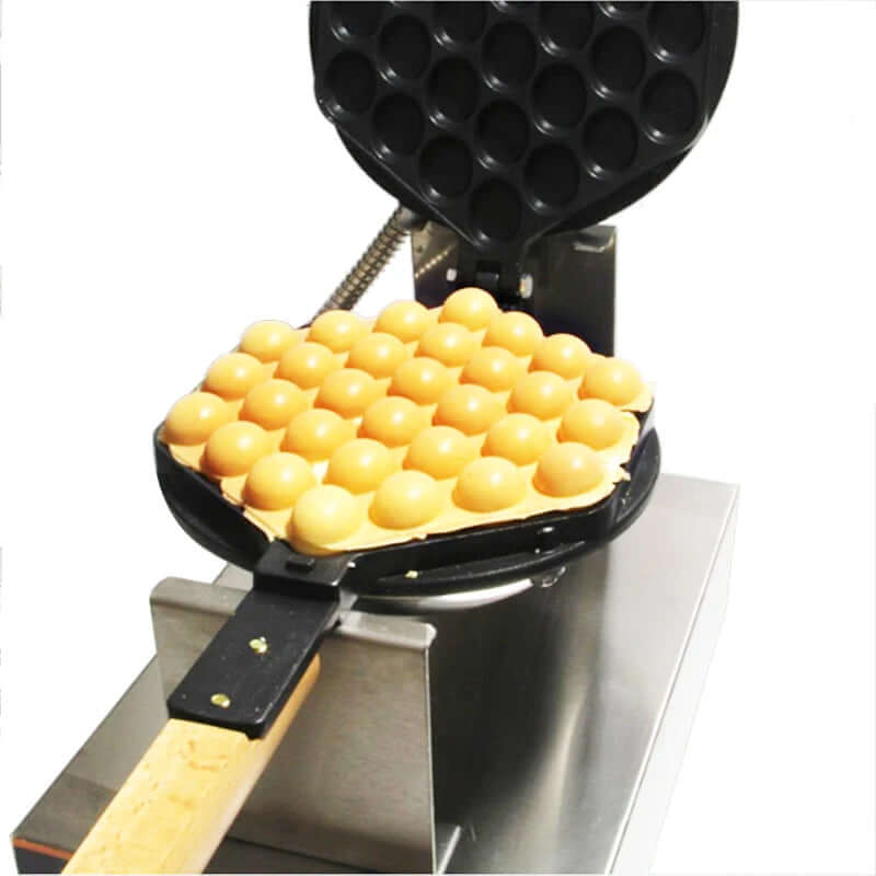Bubble waffle maker with freshly cooked golden bubble waffles on a stainless steel base