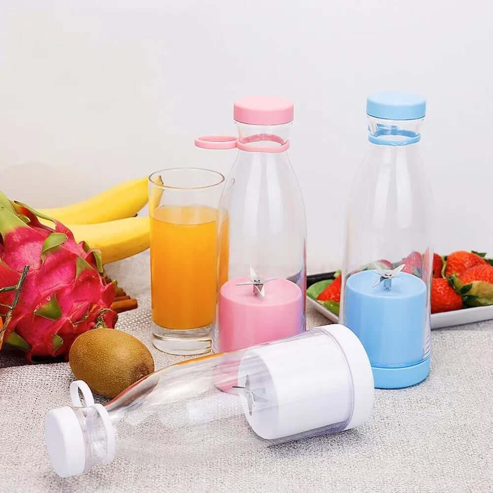 Portable mini blenders with pink, blue, and white bases on kitchen counter with fruit and juice