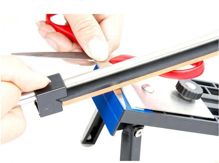 Sharpening scissors with a kitchen knife sharpening tool on a countertop