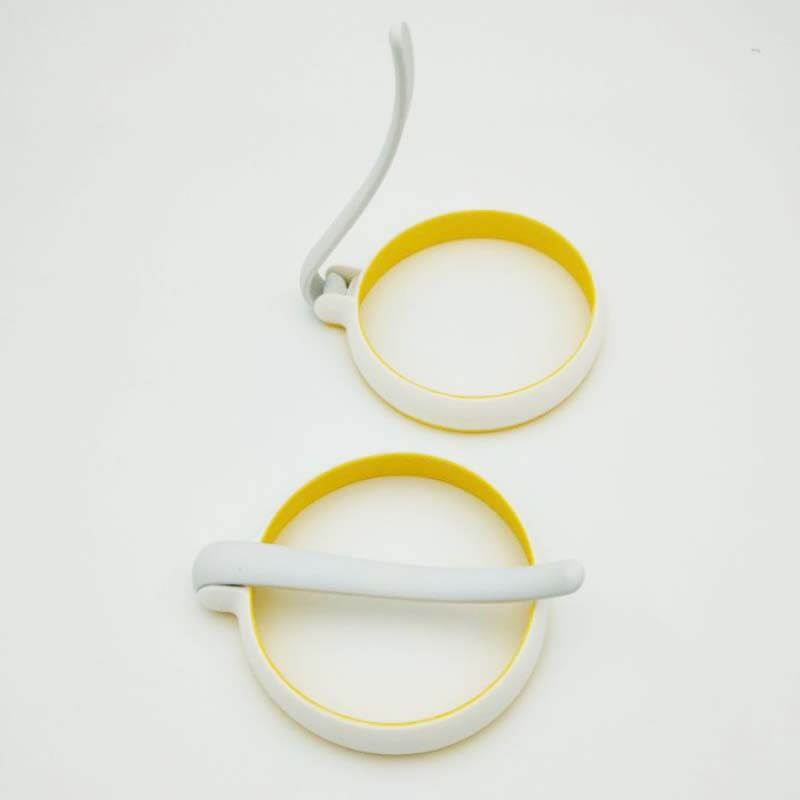 Non-stick silicone egg rings with handles for perfect round eggs or pancakes on white background