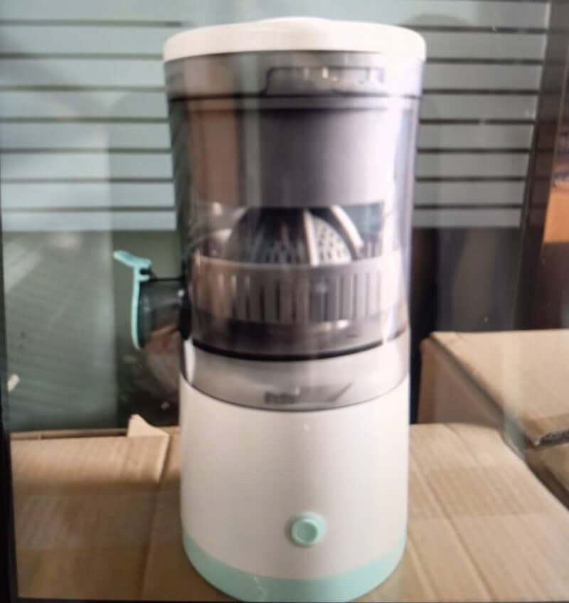 Electric citrus juicer machine with transparent container on a kitchen counter