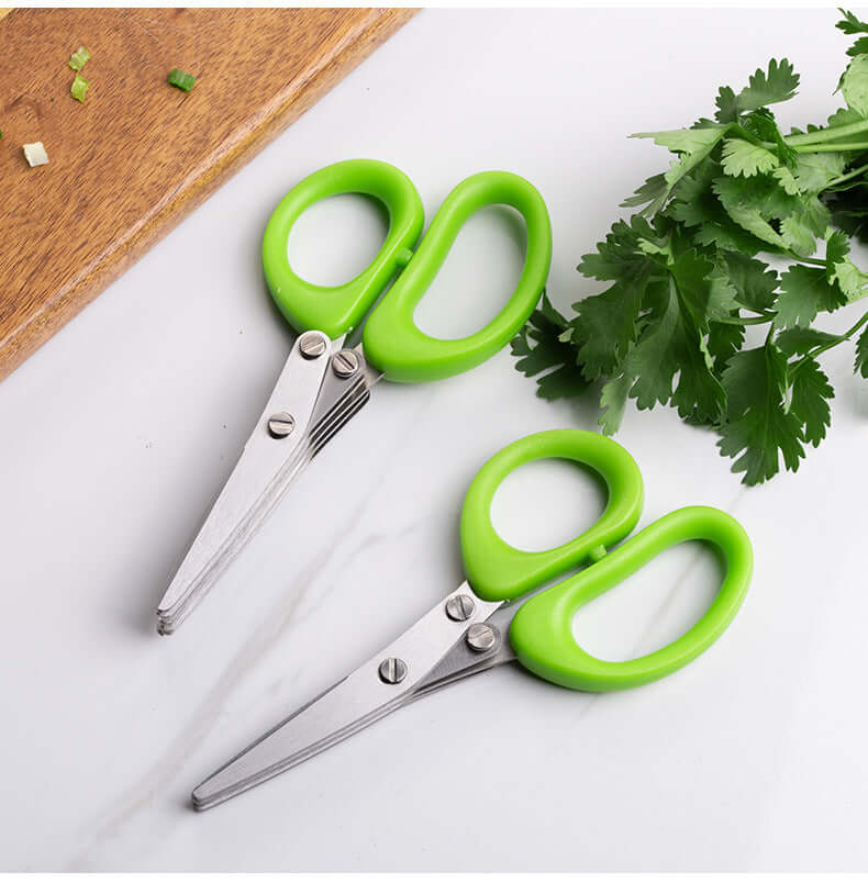 Green herb scissors with multiple blades and parsley on a kitchen countertop