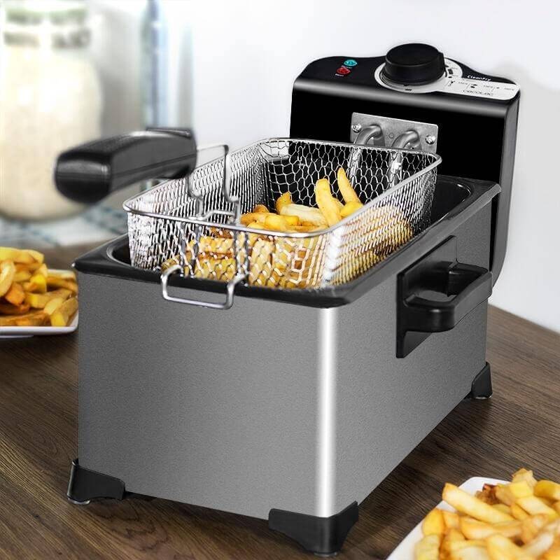 Electric deep fryer with fries in basket on kitchen counter, modern kitchen appliance