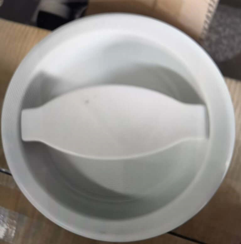 White plastic kitchen strainer bowl with integrated handle on wooden surface