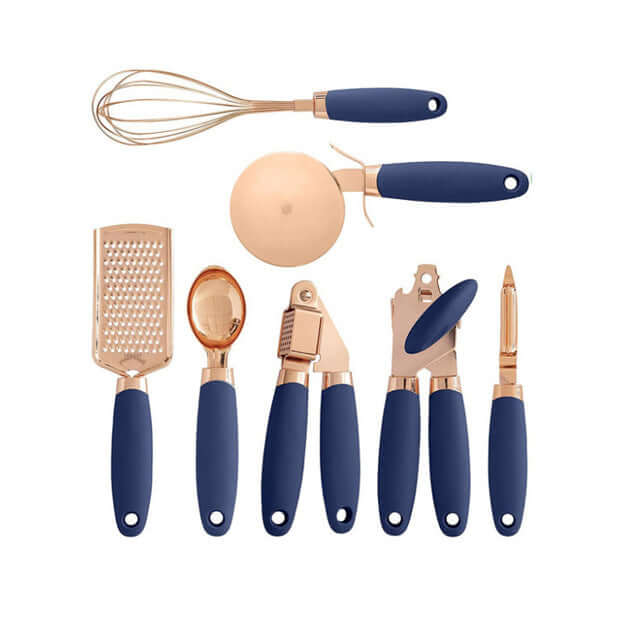 Set of gold and navy blue kitchen utensils including whisk, pizza cutter, grater, scoop, peeler.