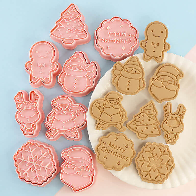 Christmas-themed cookie cutters and embossed cookies with Santa, snowman, tree, and reindeer designs