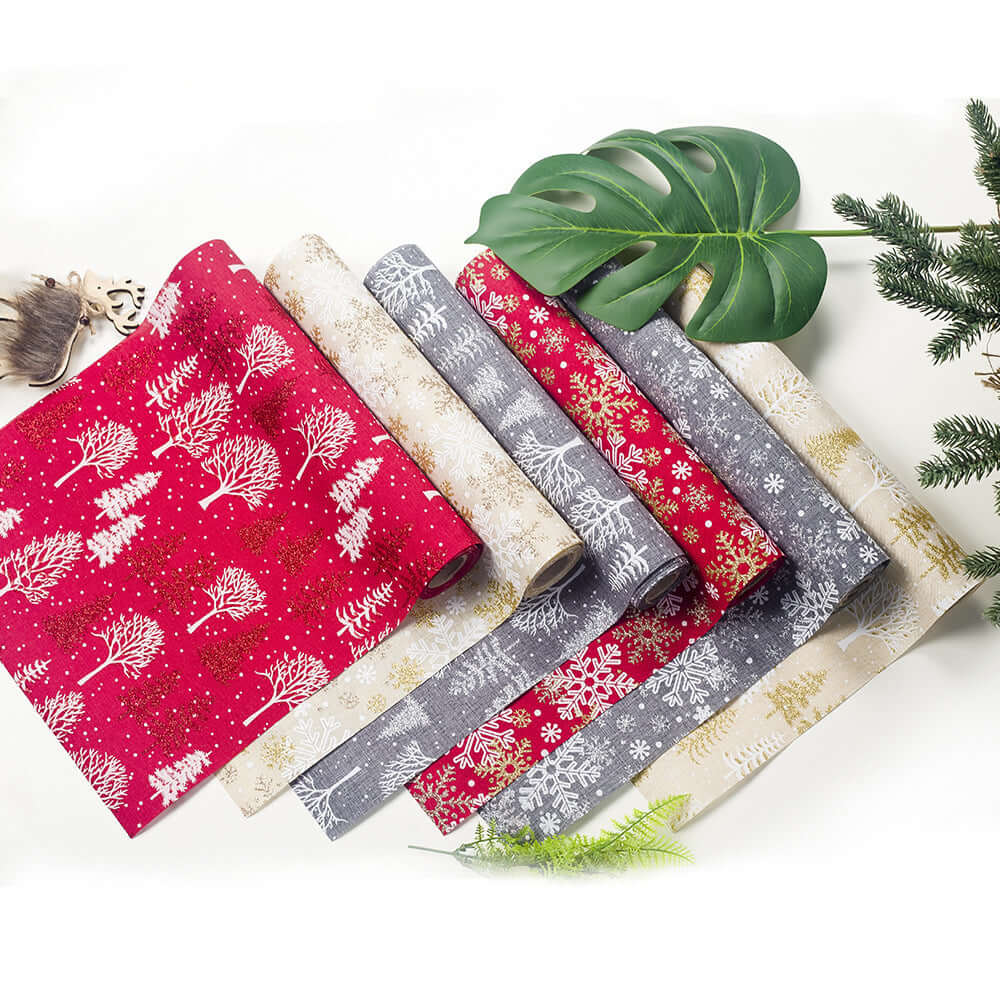 Assorted festive table runners with Christmas tree and snowflake patterns in red, gray, and beige.