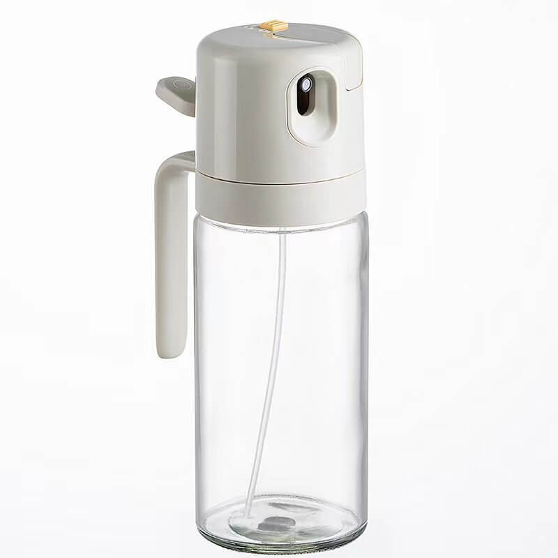 Clear glass kitchen oil sprayer bottle with white plastic pump top and handle
