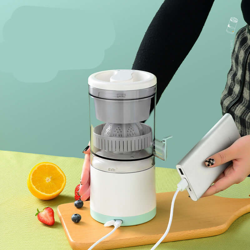 Electric citrus juicer for kitchen, USB powered, with fruit on table