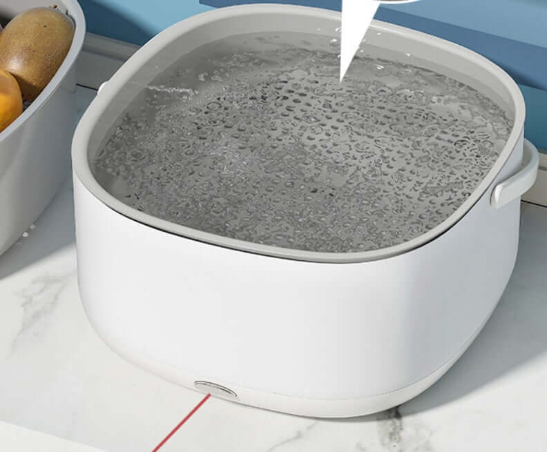 White kitchen appliance or container filled with bubbling water on marble countertop