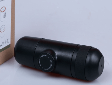 Portable black manual coffee grinder with dial, countertop kitchen accessory