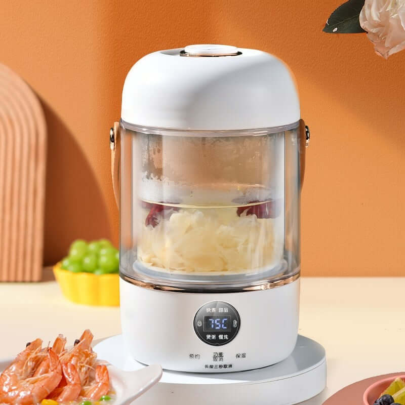 Electric glass food steamer with digital display on kitchen counter, steaming vegetables