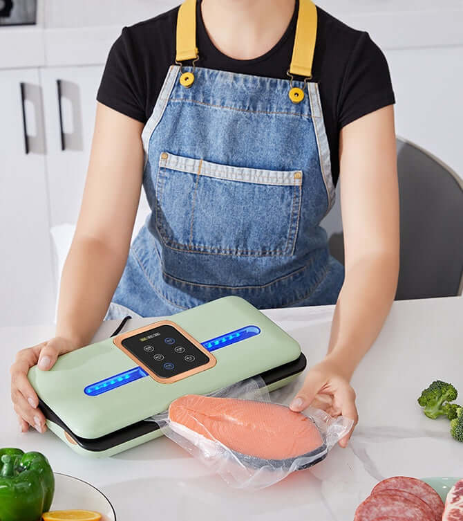Person using a vacuum sealer for food with salmon fillet in kitchen setting