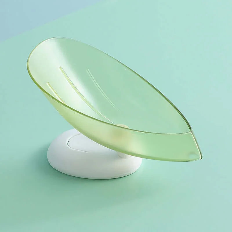 Leaf-shaped green plastic soap dish with drainage on white base, modern kitchen accessory