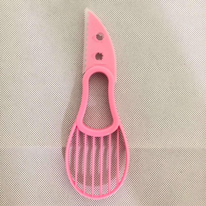Pink plastic multifunctional kitchen tool with knife blade and slotted slicer design