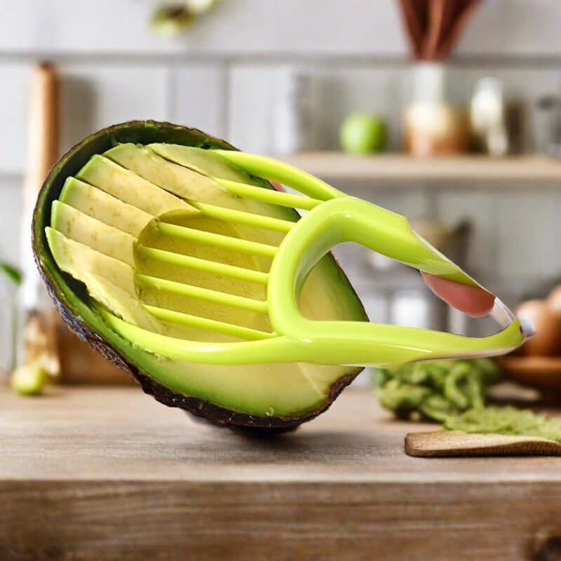 Green avocado slicer tool cutting ripe avocado on kitchen countertop