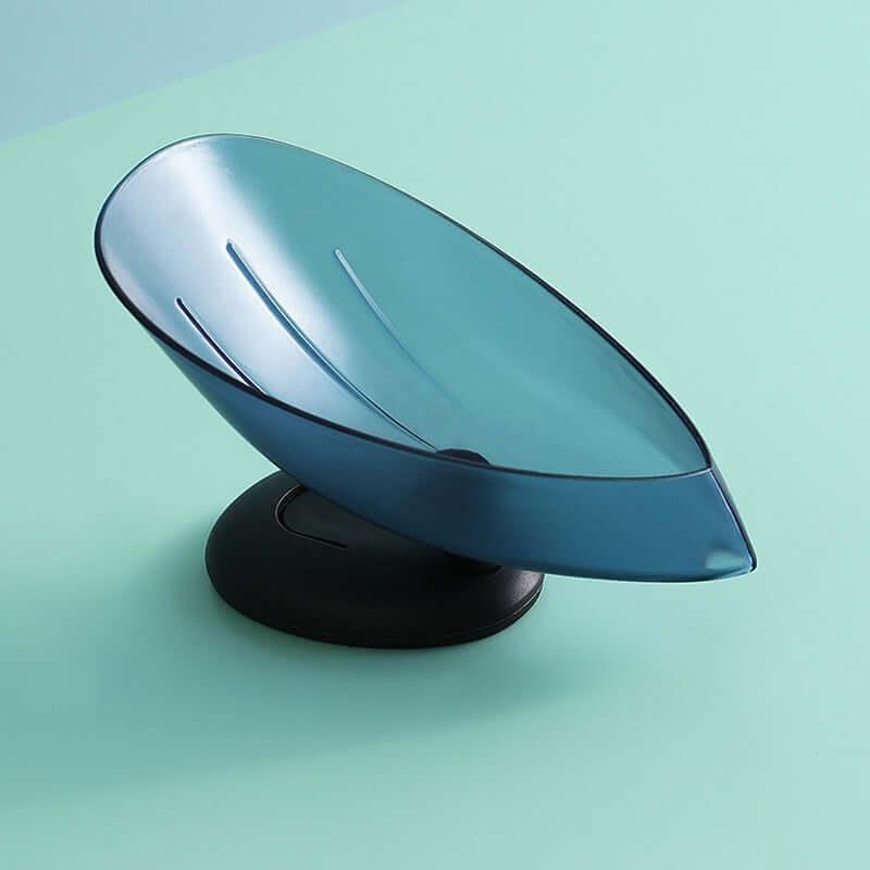 Blue plastic kitchen spoon rest with a black non-slip base on a light teal surface