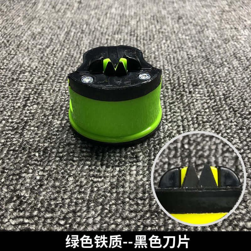 Green and black kitchen knife sharpener with suction base on textured surface, close-up view.