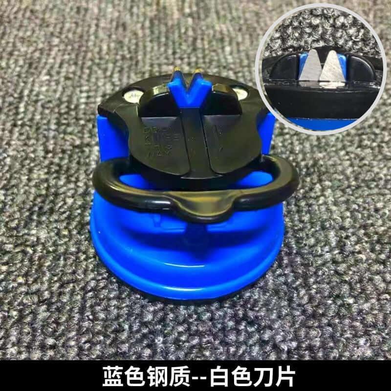 Blue kitchen knife sharpener with black handle on textured surface, close-up of sharpening slot