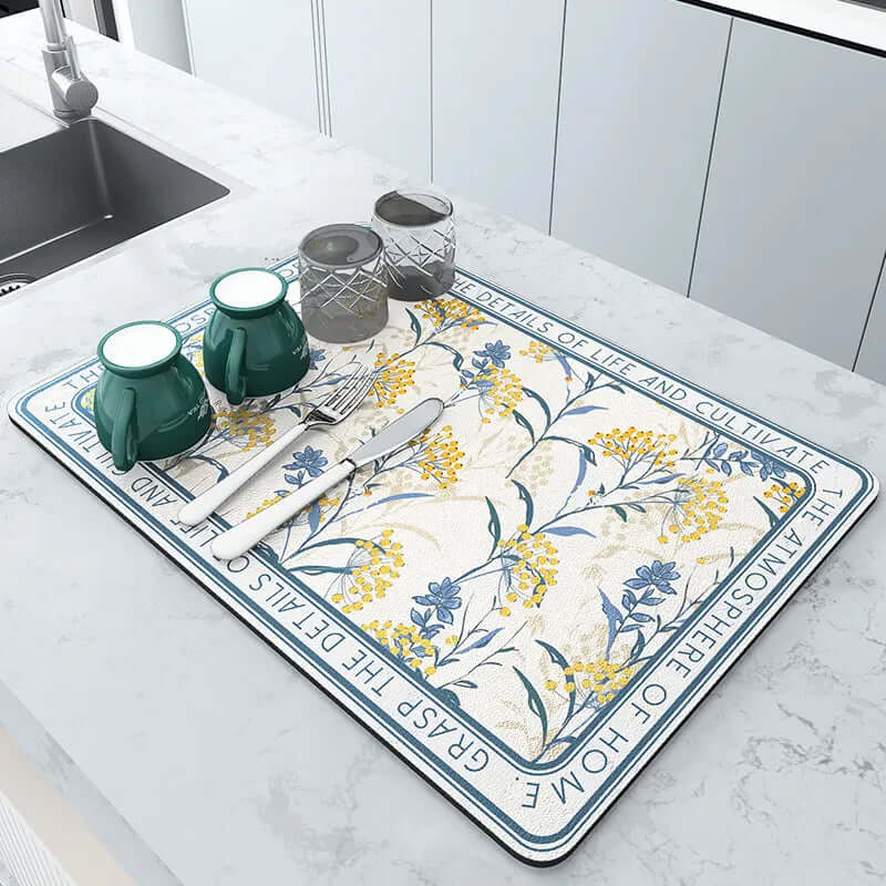 Floral kitchen drying mat on countertop with mugs, glasses, and utensils
