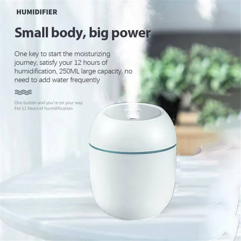 Compact white humidifier with 250ml capacity on tabletop, producing visible mist indoors