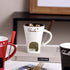 Ceramic fondue mug with chocolate, tealight warmer, and fondue fork on a table
