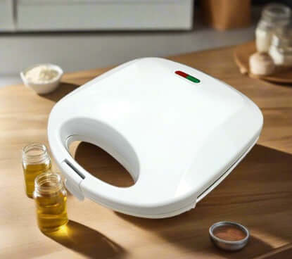 White sandwich maker appliance on kitchen counter with oil jars and baking ingredients