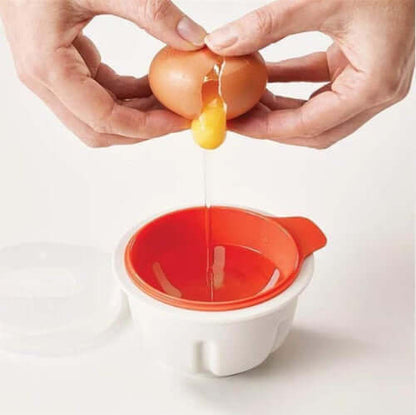 Cracking an egg into a white and red egg separator kitchen accessory