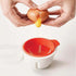 Cracking an egg into a white and red egg separator kitchen accessory