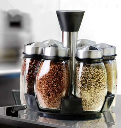 Rotating spice rack set with glass jars filled with kitchen herbs and seasonings