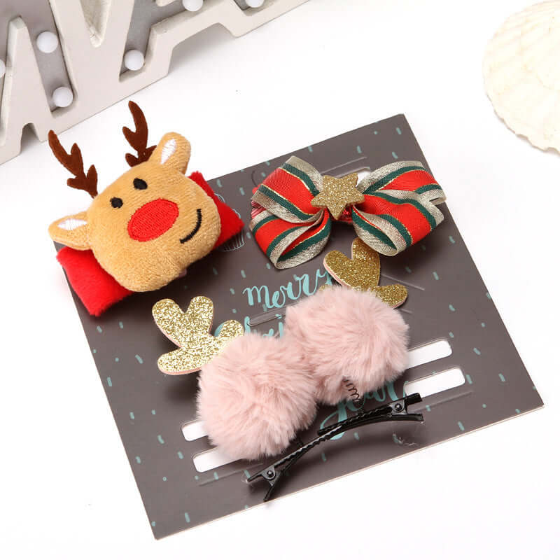 Set of festive Christmas hair clips featuring a reindeer, bow, glitter shapes, and fluffy pom pom