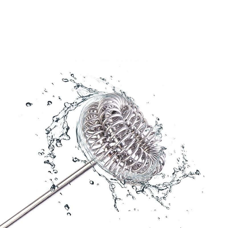 Stainless steel whisk attachment for hand mixer splashing in water, kitchen utensil cleaning
